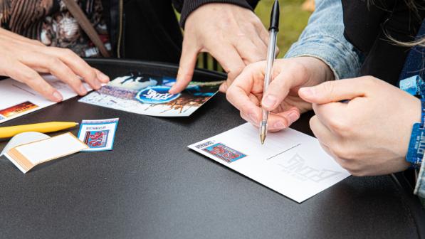 Someone writing a postcard from Rock am Ring