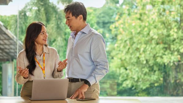 Two DHL colleagues tooking at a laptop
