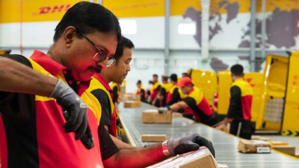 DHL Mitarbeitende in einem DHL Lagerhaus in Dubai
