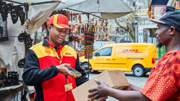 DHL Employee scans a parcel on a marketplace in Africa