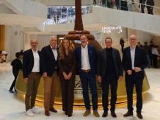 Five men and one woman standing in front of a Lindt chocolate fountain