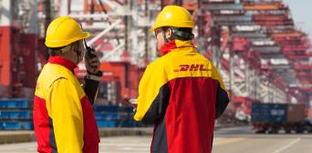 Two men in DHL jackets and yellow helmets.