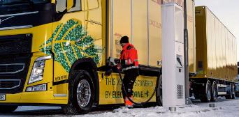 Ein Mann lädt seinen elektrischen DHL-Lastwagen auf. 