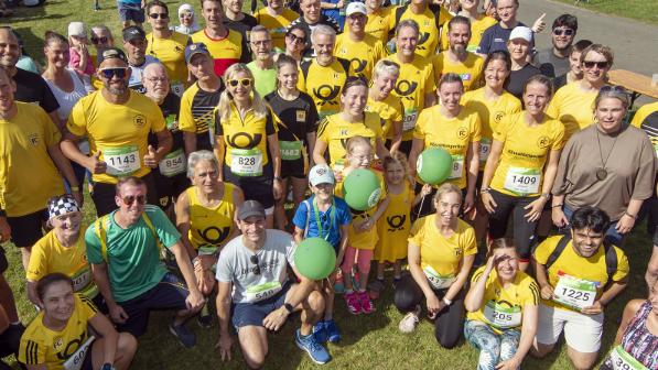 A group of employees in yellow shirts on a sunny day.