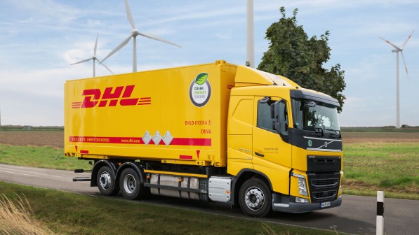 A DHL truck in front of wind turbines.