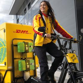 A female bicycle courier with a yellow and red DHL jacket.