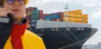 DHL employee in front of a cargo ship