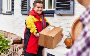 A DHL courier with an amputated arm delivering a parcel.